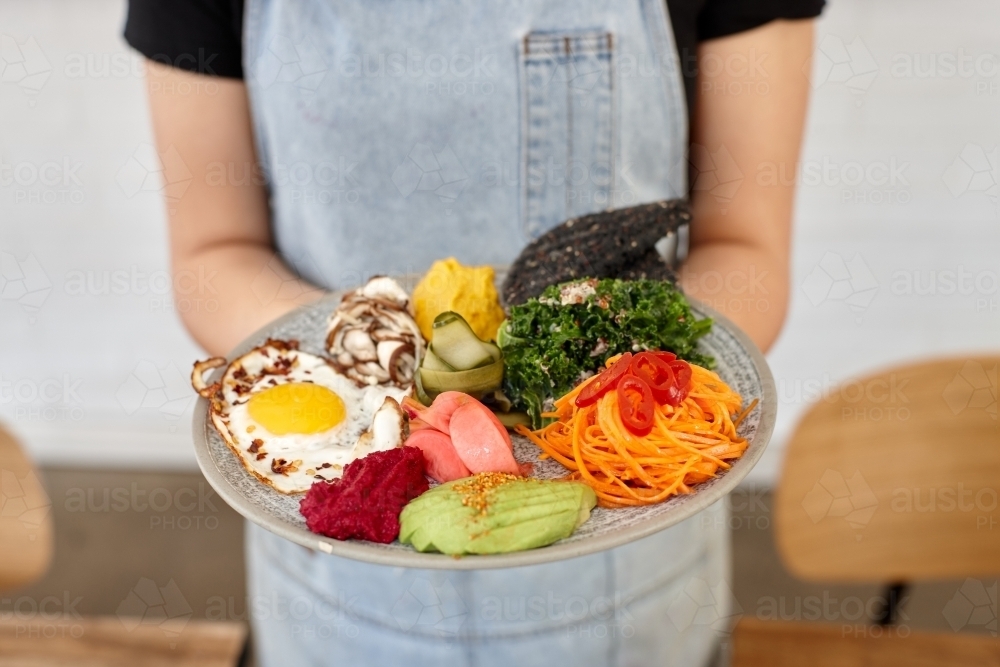 Healthy vegetarian meal being served by waiter - Australian Stock Image