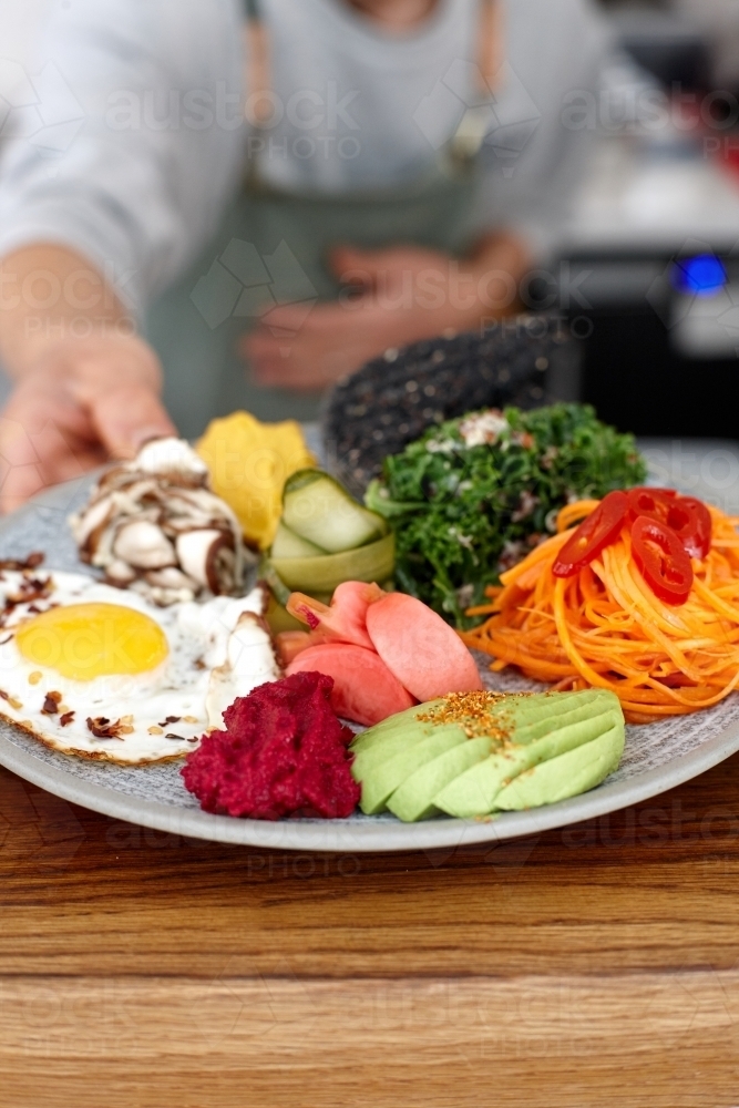 Healthy vegetarian meal being served on table - Australian Stock Image