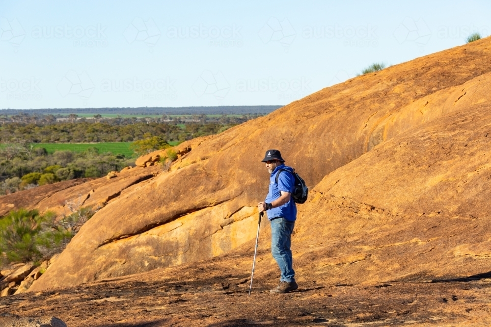 hiker standing on granite rock in the wheatbelt - Australian Stock Image