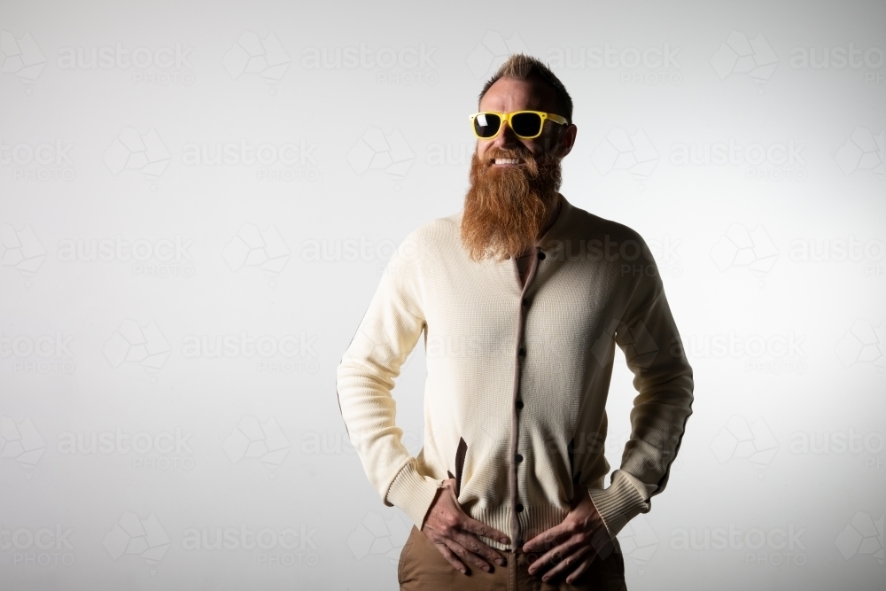 Hipster in cardigan and sunglasses posing for photo - Australian Stock Image