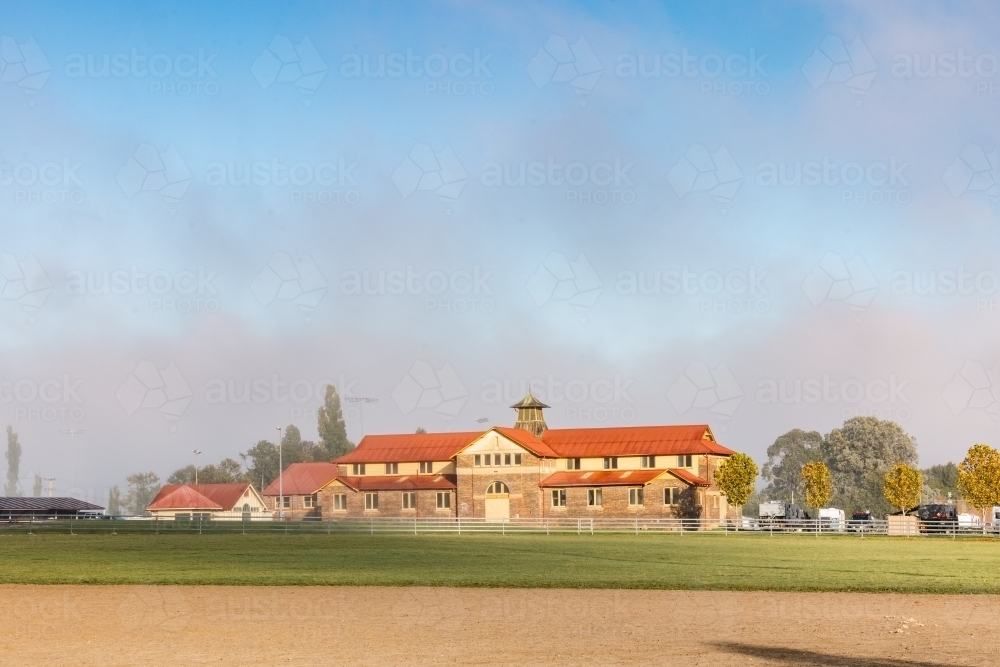 Historic Armidale Showground Pavilion on foggy autumn morning with arena in foreground - Australian Stock Image