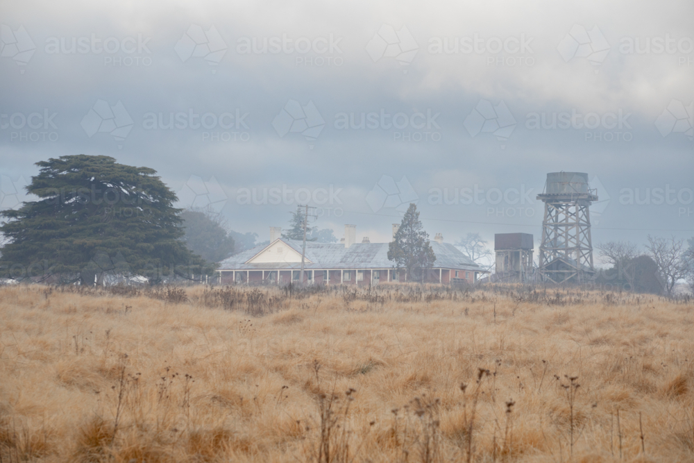 Historic old country home, water tank and a winter morning - Australian Stock Image