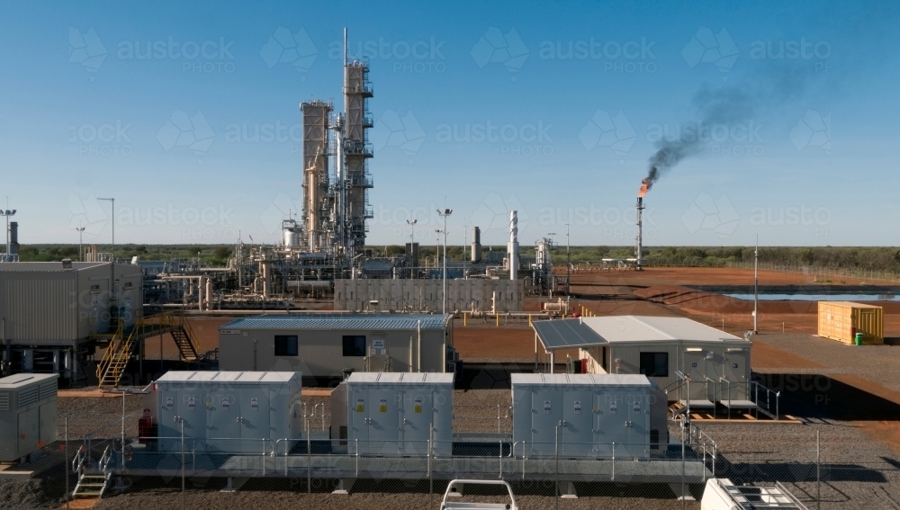 Horizontal photo of a power plant with a smoking flue-gas stack and cranes. - Australian Stock Image