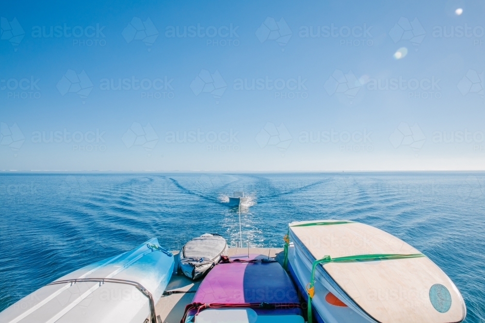 Horizontal shot of a boat with surfboards while towing another boat - Australian Stock Image