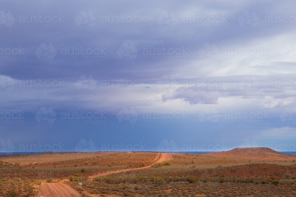 Horizontal shot of a dirt track through barren land - Australian Stock Image