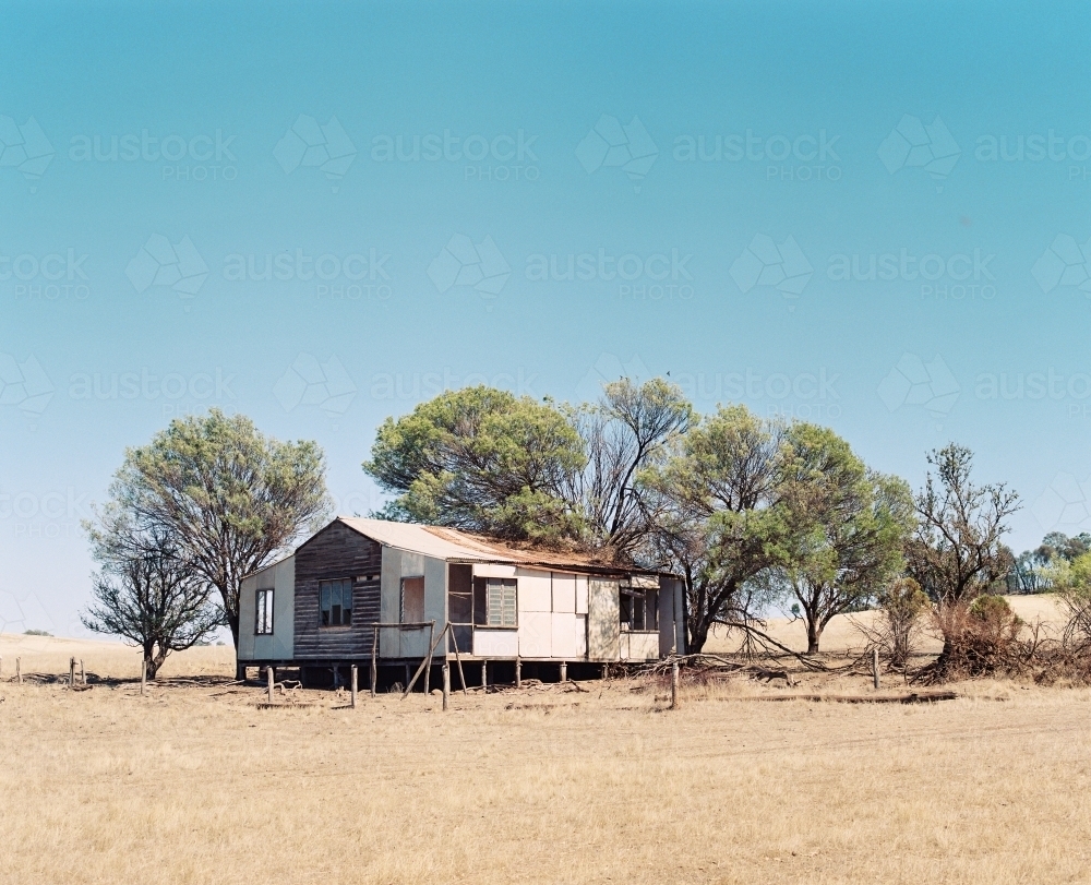 Horizontal shot of a house with trees behind on a sunny day - Australian Stock Image