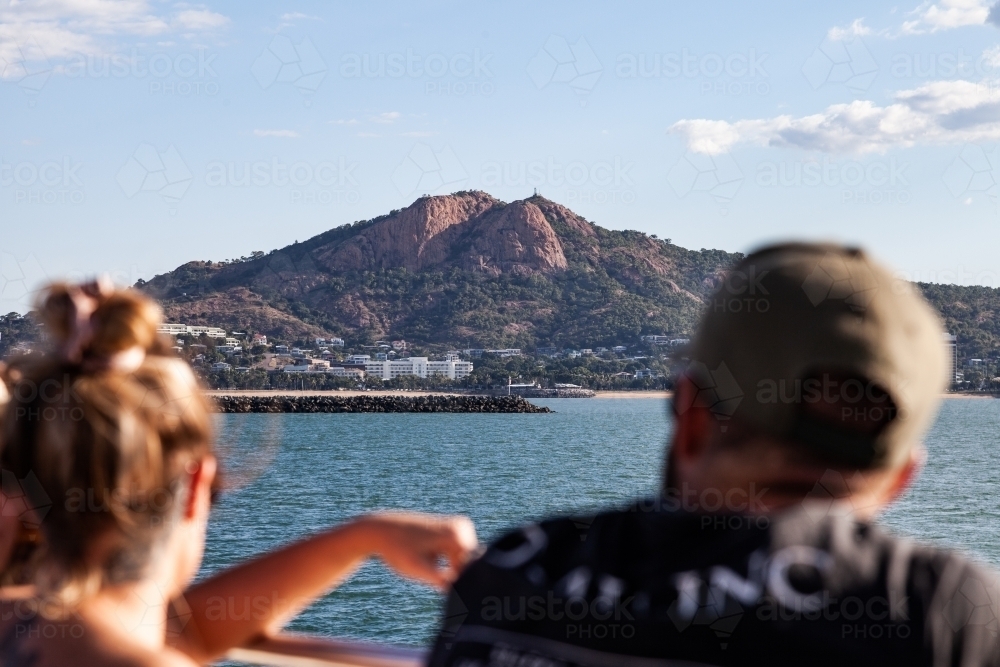 horizontal shot of a mountain with ocean view and a man and woman in the foreground - Australian Stock Image