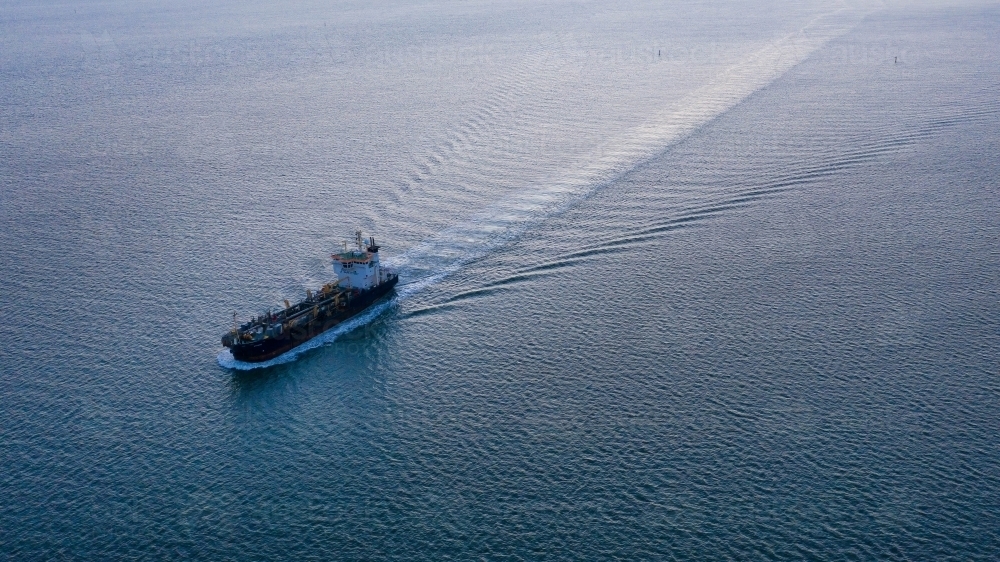 Horizontal shot of a ship leaving a wake on water - Australian Stock Image