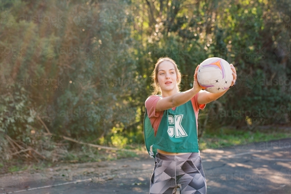 Horizontal shot of a woman holding a ball with her sportswear - Australian Stock Image