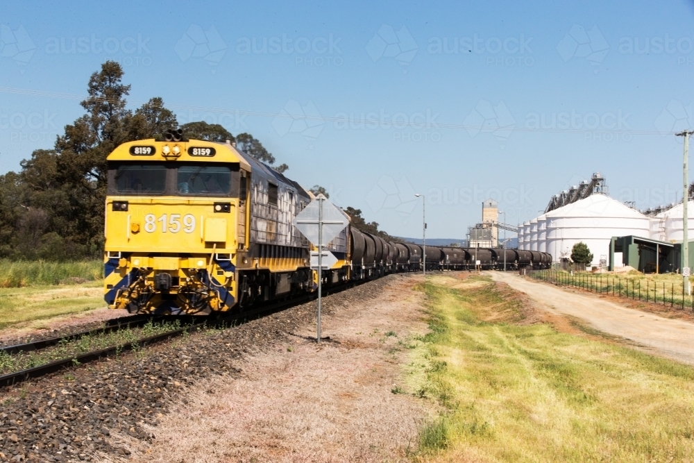 Horizontal shot of a yellow train on the railway in a rural area - Australian Stock Image