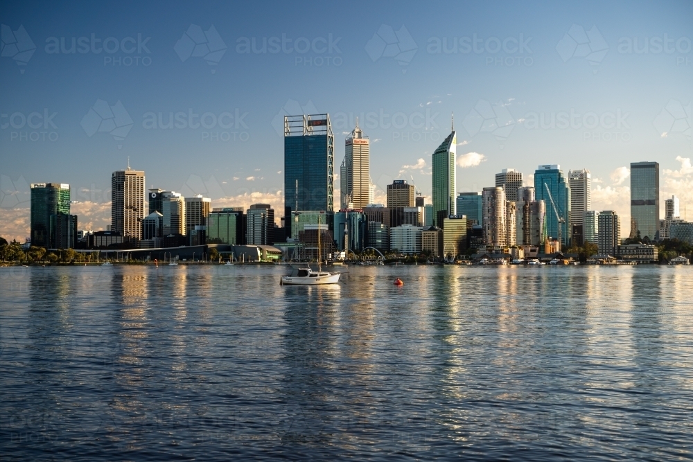 Horizontal shot of buildings facing the ocean with reflection on water - Australian Stock Image