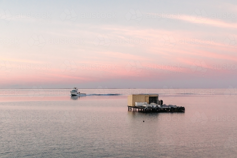 Horizontal shot of commercial cray fishing boats at sunrise with shack. - Australian Stock Image