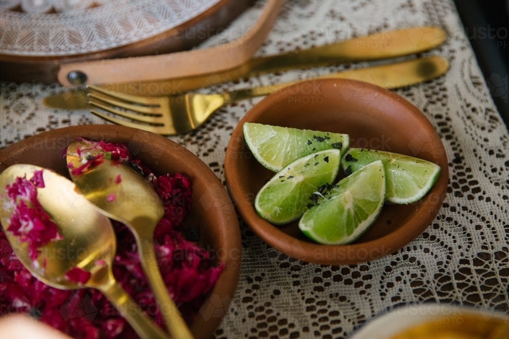 Horizontal shot of fresh lime in a small bowl on a table - Australian Stock Image