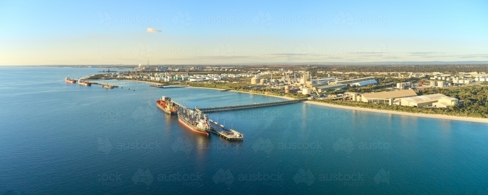 Panoramic shot of Kwinana bulk jetty with large ship docked at the port on a sunny day - Australian Stock Image