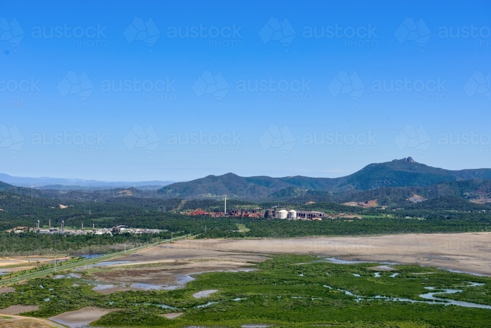 Horizontal shot of mudflats and industrial sites near Gladstone - Australian Stock Image