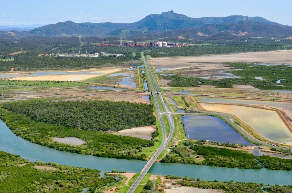 Horizontal shot of road leading to industrial sites near Gladstone - Australian Stock Image