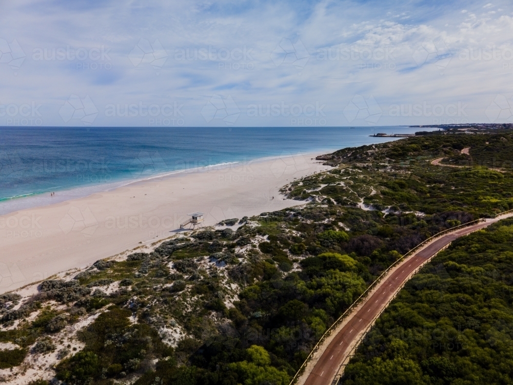 horizontal shot of Summers in Perth with white sand, green trees ocean water and a walking path - Australian Stock Image