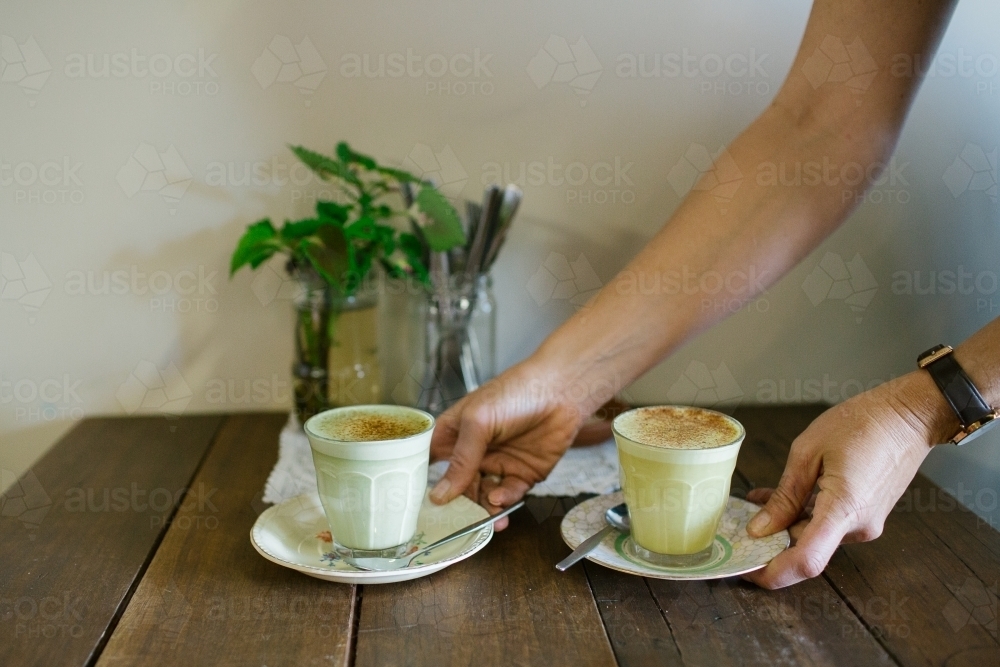 Horizontal shot of two coffees served on a wooden table - Australian Stock Image