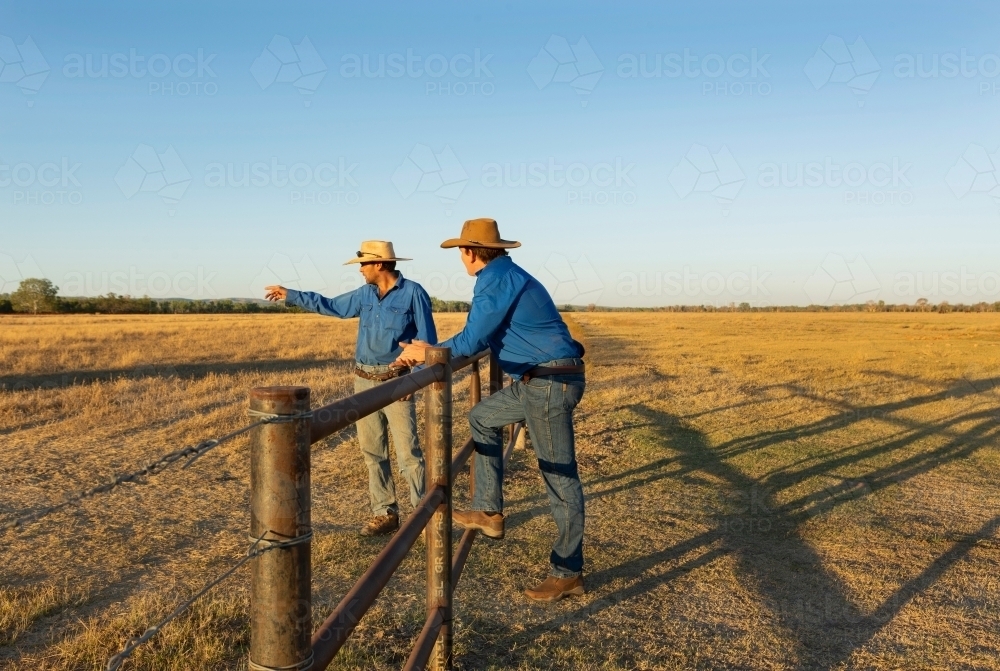 Horizontal shot of two men talking while mustering cattle - Australian Stock Image