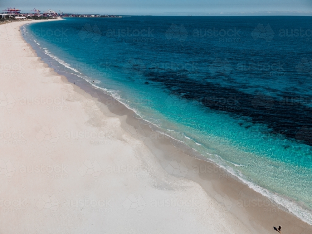 horizontal shot of white sand beach with waves and seaweeds on a sunny day - Australian Stock Image