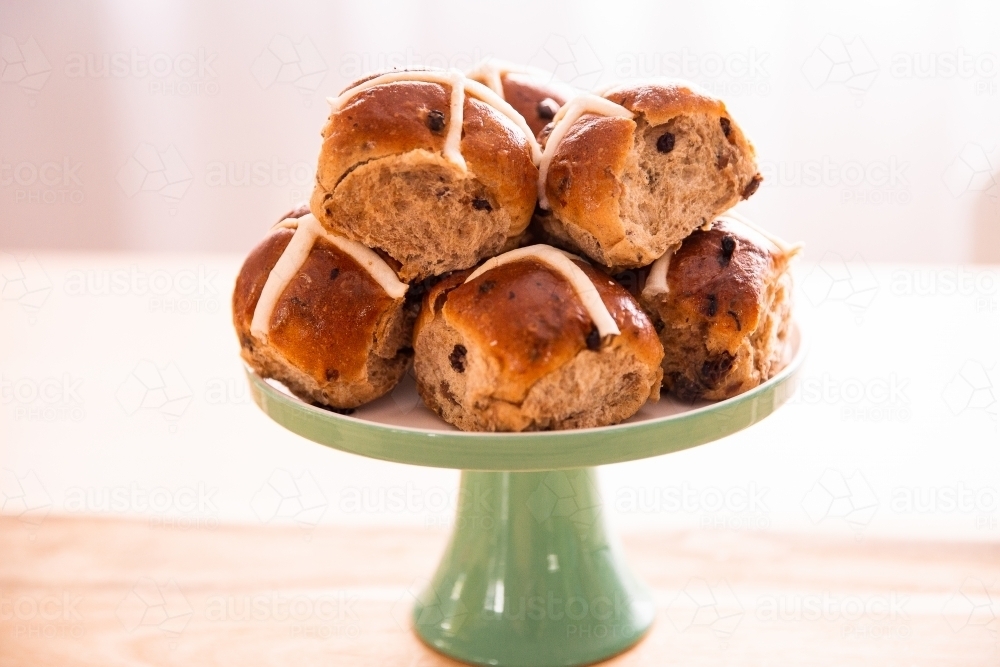 hot cross buns piled up on a green stand ready to eat - Australian Stock Image