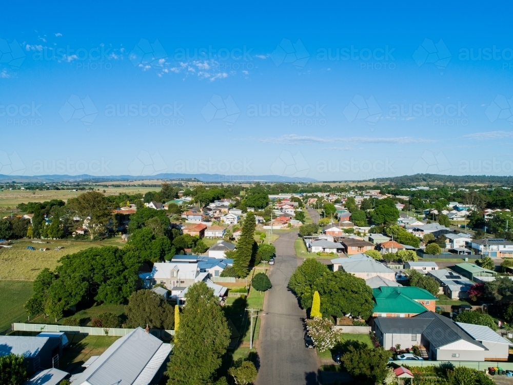 Houses beside street at edge of country town under blue australian sky - Australian Stock Image