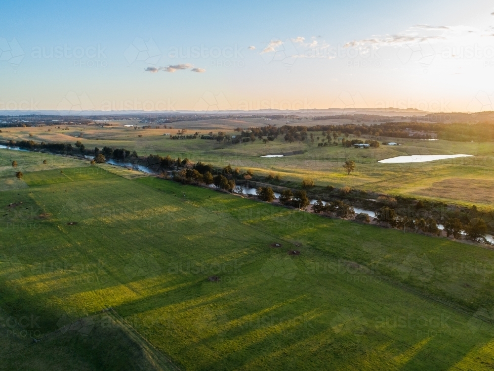 Hunter River flowing between green farm paddocks in Hunter Valley  - Australian Stock Image