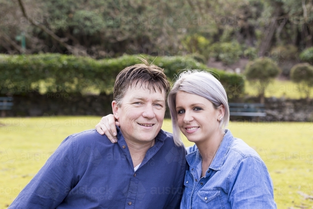 image-of-husband-and-wife-in-embrace-looking-at-camera-austockphoto