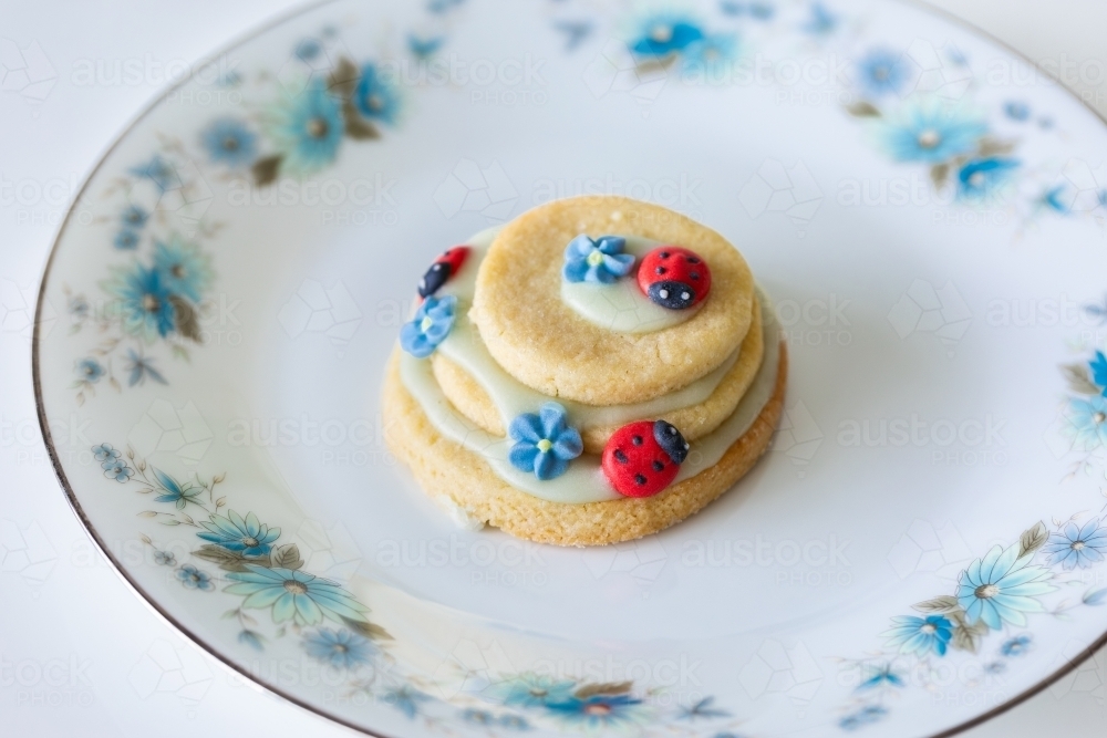 Icing sugar ladybugs on stacked biscuit birthday party treats   - Australian Stock Image