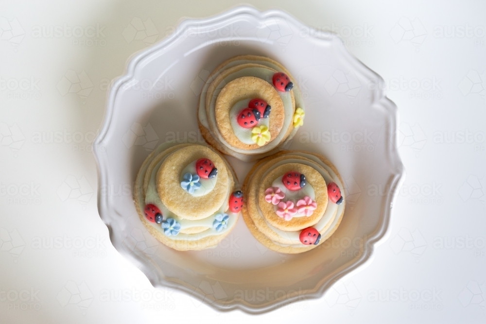 Icing sugar ladybugs on stacked biscuit birthday party treats   - Australian Stock Image