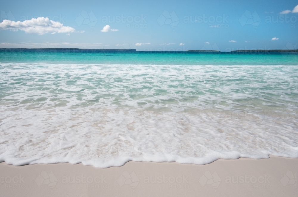 Idyllic water and small waves on white sandy beach - Australian Stock Image