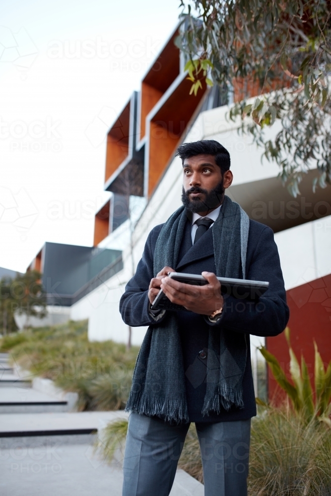 Indian architect using touchscreen device to survey site - Australian Stock Image