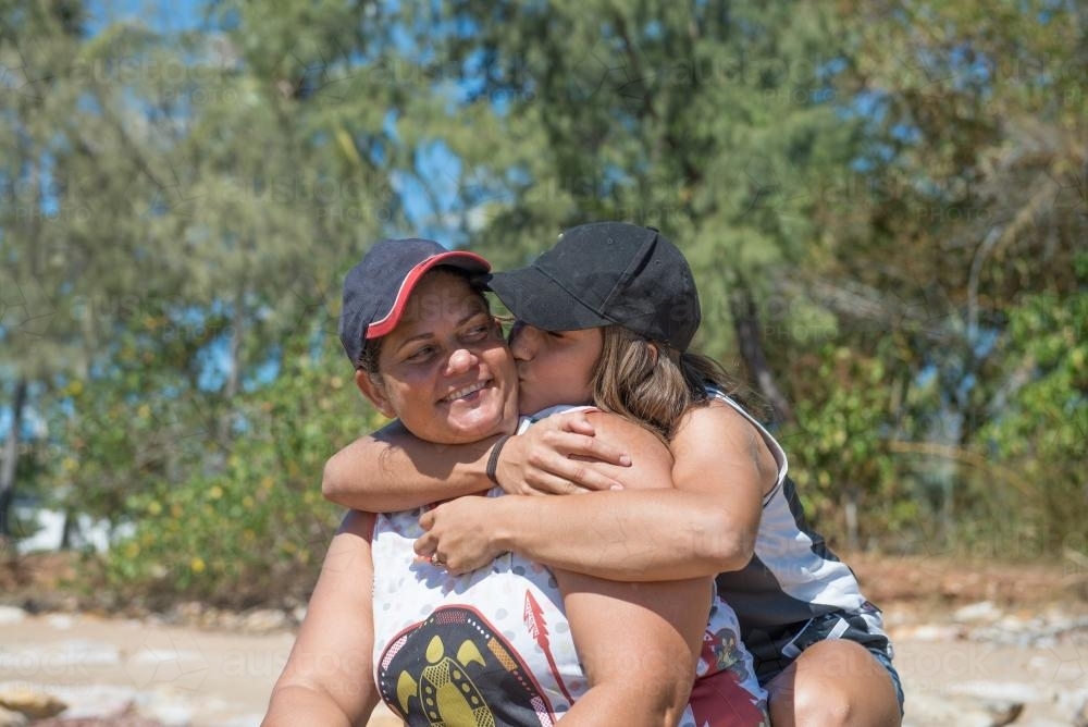 Indigenous mother and daughter hugging - Australian Stock Image