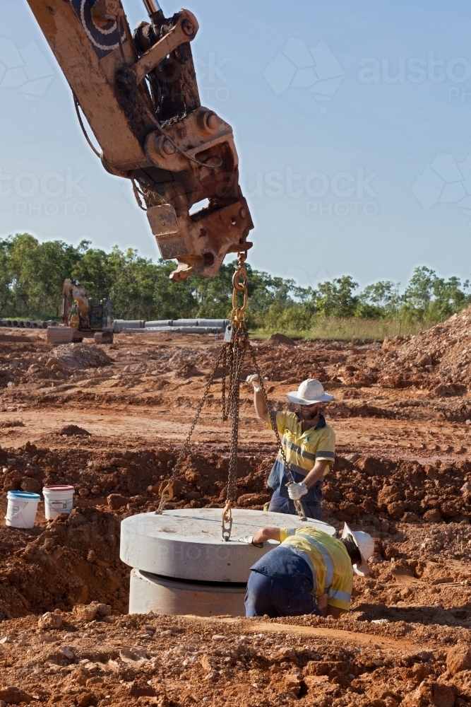 Industrial workers overseeing heavy machinery on a building site - Australian Stock Image