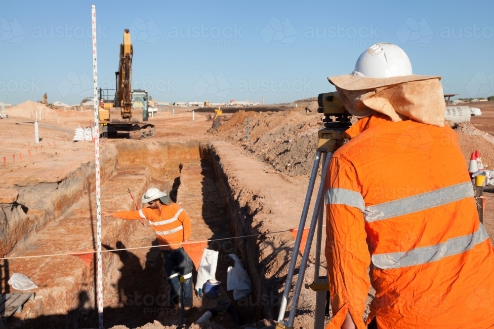 Industrial workers surveying a large building site - Australian Stock Image
