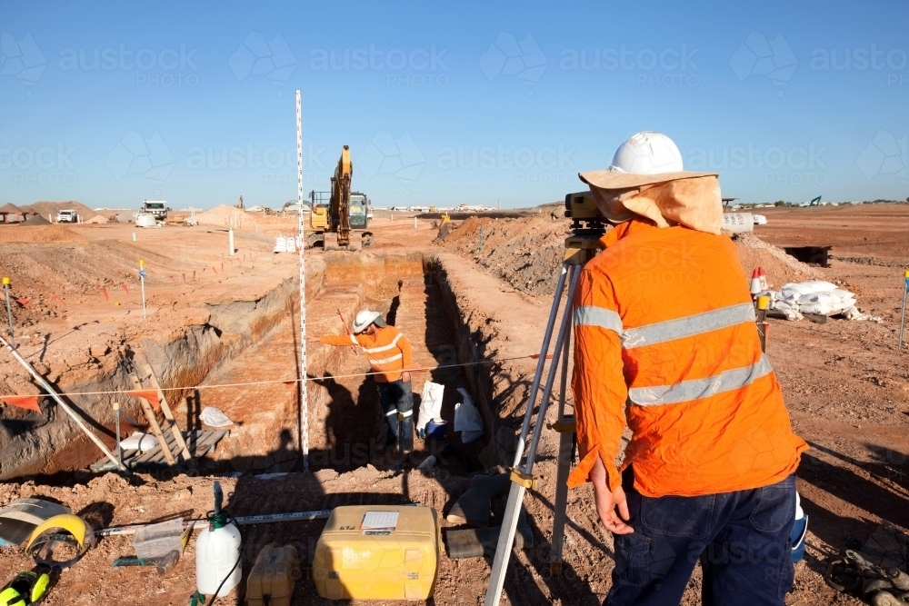 Industrial workers surveying a large building site - Australian Stock Image