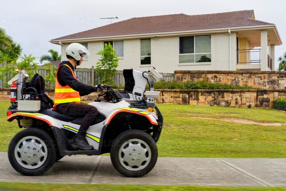 Infrastructure management mobile  man on quad bike testing pavements and walkways in suburban places - Australian Stock Image