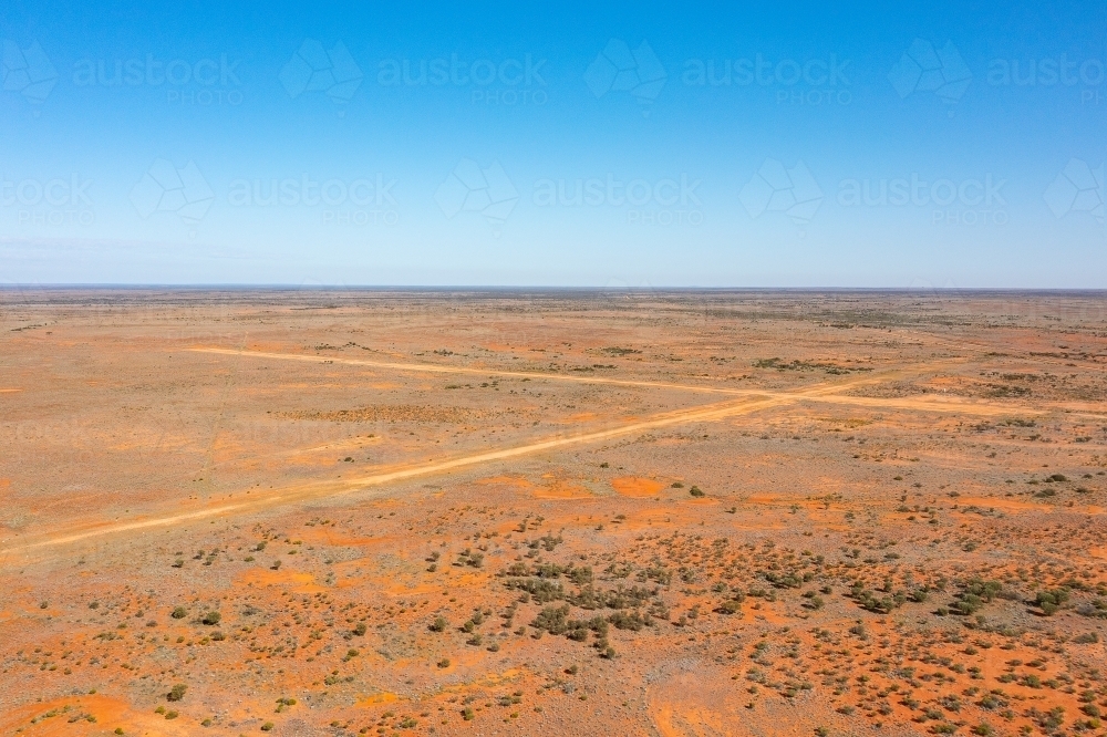 Intersecting runways of unsealed airstrip mark an x in the outback landscape at Kingoonya - Australian Stock Image