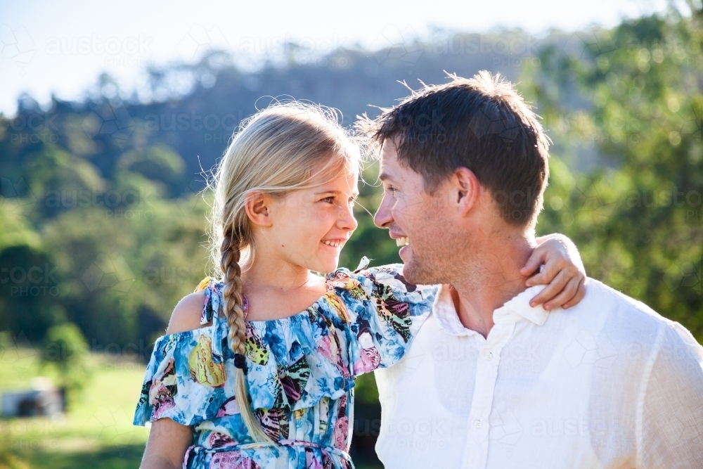 Intimacy or father and daughter looking at one another smiling outside on farm - Australian Stock Image