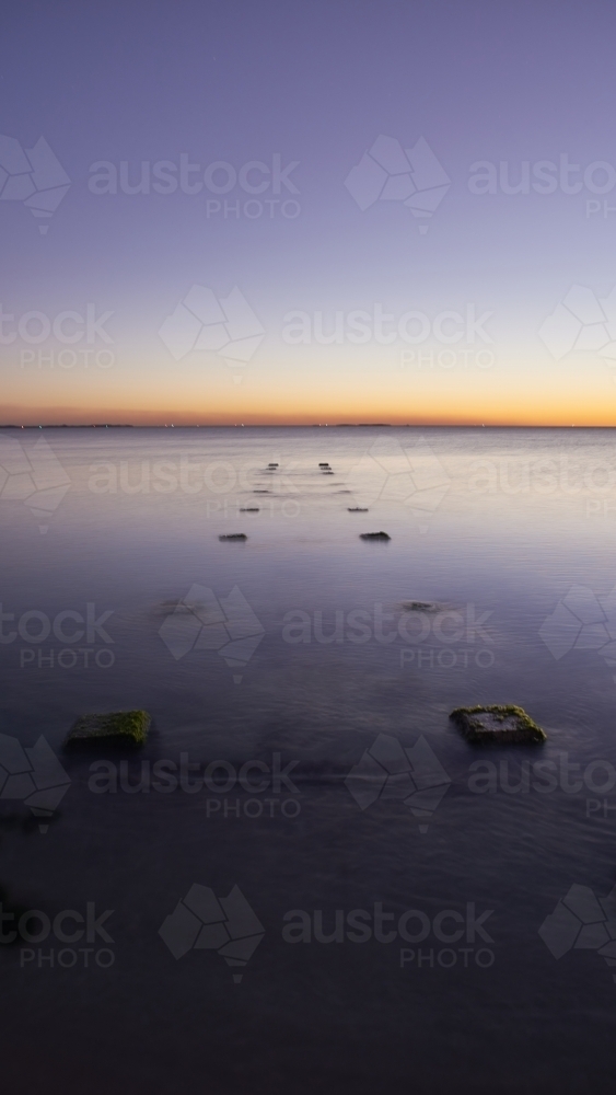 Jetty ruins at dusk in the ocean long exposure. - Australian Stock Image