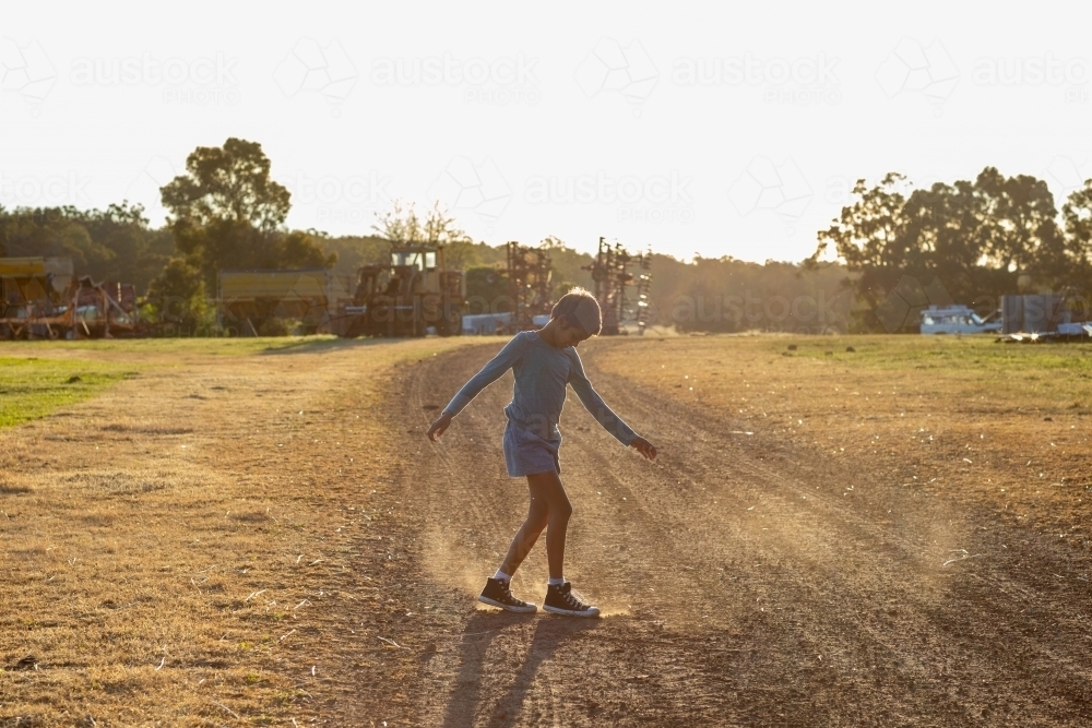 kid dancing in the dirt on a farm - Australian Stock Image