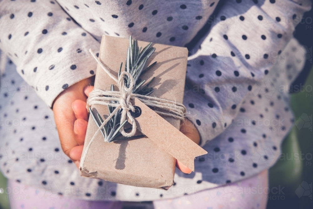 kid holding eco gift box with brown tag - Australian Stock Image