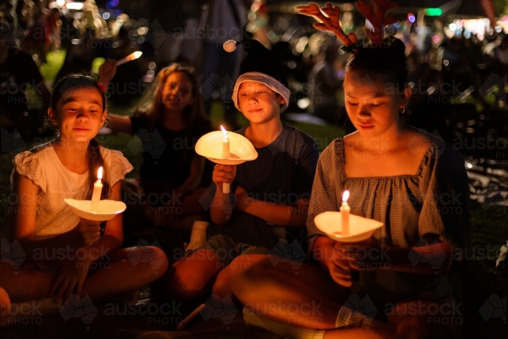 kids holding candles at carols by candlelight - Australian Stock Image