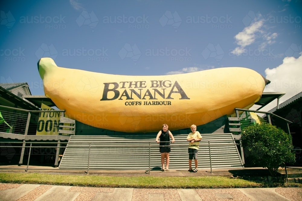 Kids posing in front of The Big Banana tourist attraction at Coffs Harbour - Australian Stock Image