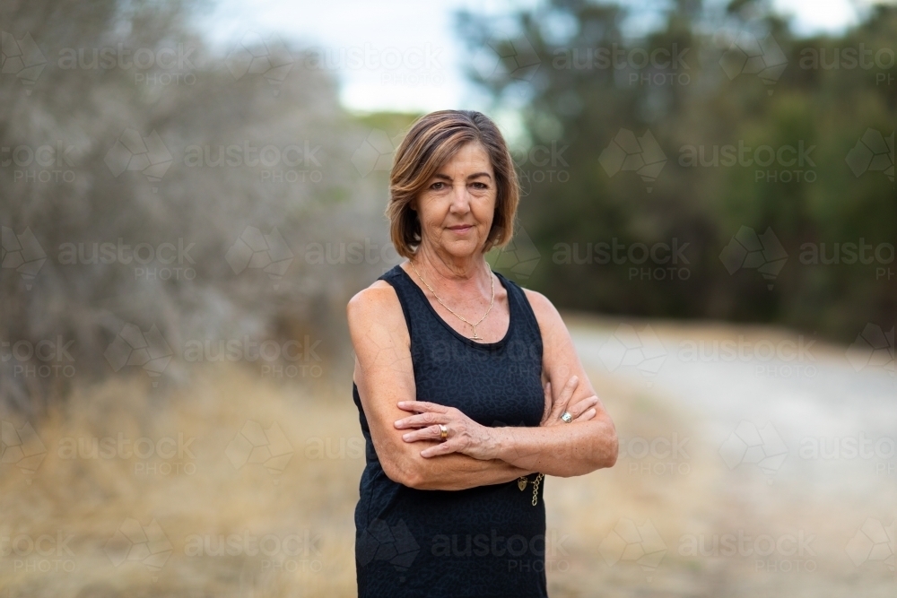 lady in black with crossed arms looking at camera - Australian Stock Image