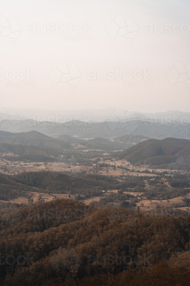 Landscape with hazy mountain views behind a valley in regional New South Wales. - Australian Stock Image