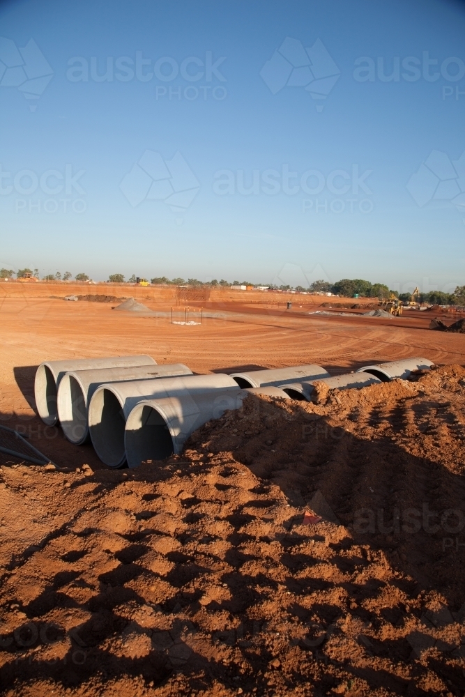 Large cement pipes arranged on a large industrial building site - Australian Stock Image