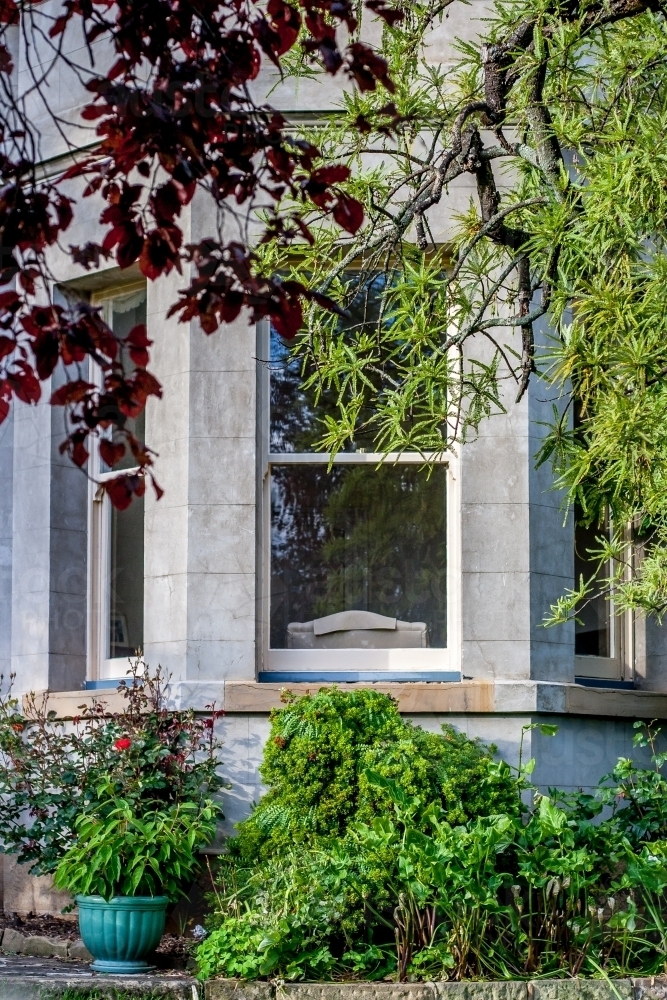 Large window of sandstone building with gardens around - Australian Stock Image