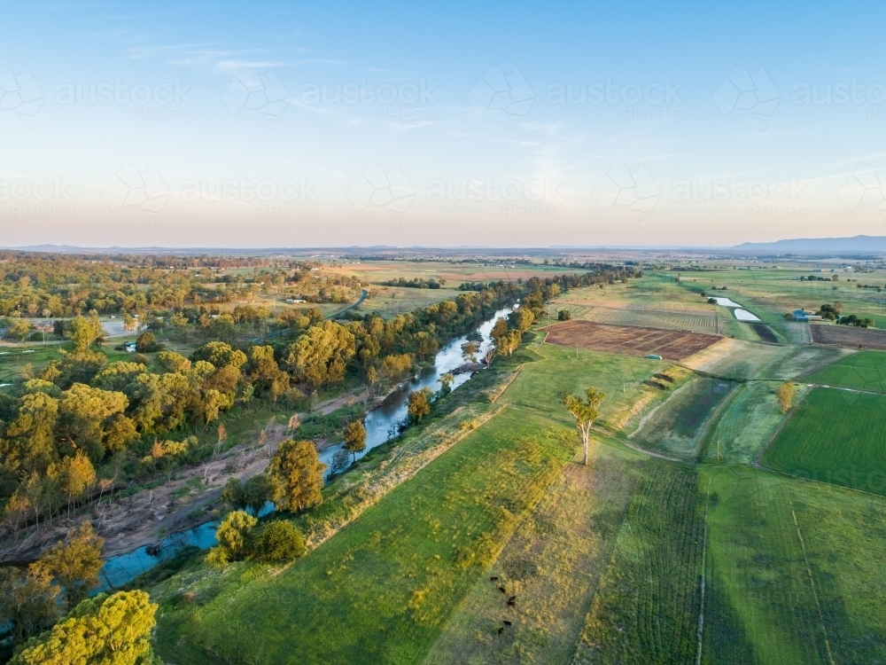 Last light of the day over riverside farm paddocks in rural NSW - Hunter River Redbournberry - Australian Stock Image