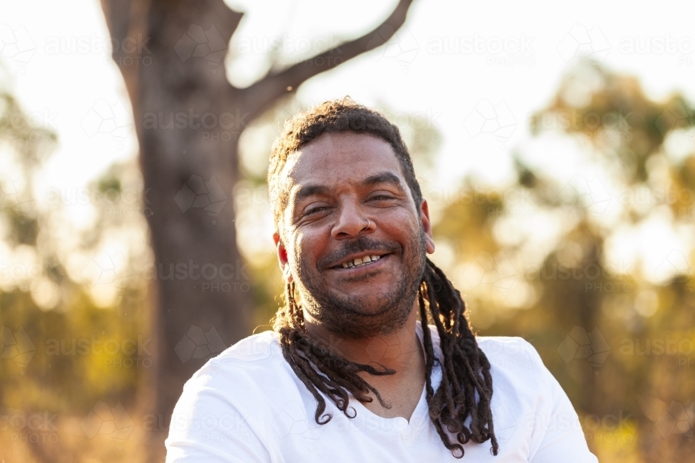 Laughing aboriginal man in Australian country setting - Australian Stock Image